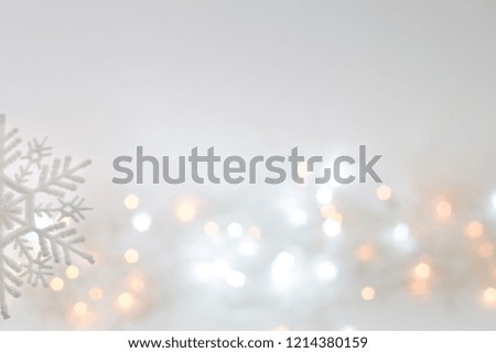 Large snowflake on a festive Christmas background with bokeh from the Christmas lights. White, blue, yellow blurred light