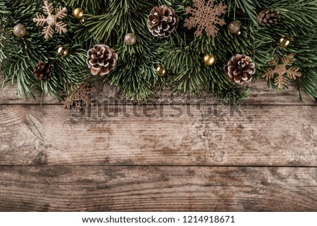 Creative layout frame made of Christmas fir branches, pine cones and gold decoration on wooden background. Xmas and New Year theme. Flat lay, top view
