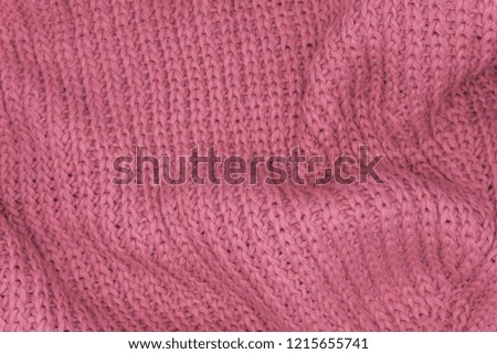 Texture of a pink knitted sweater closeup, red knitted wool