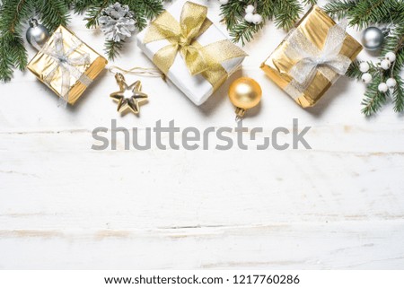 Christmas background. Gold and silver decorations and present box on white wooden background. Top view with copy space.
