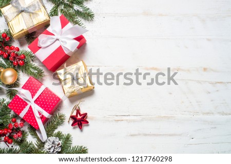 Red and Gold present box and decorations on white wooden background. Top view with copy space.