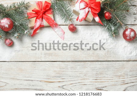 Flat lay composition with Christmas decor, snow and space for text on wooden background. Festive winter design