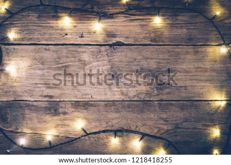 Christmas lights frame on wooden rustic background with (decorated) cristmas light. Copy space. Top view