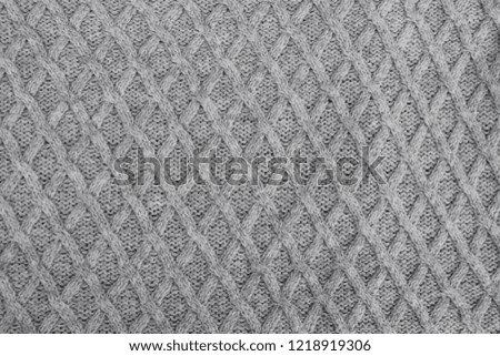 Gray knitting wool fabric pattern as textured knitted background top view.
