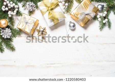 Christmas background. Gold and silver decorations and present box on white wooden background. Top view with copy space.