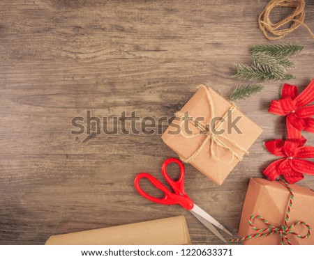 Christmas gift box and wrapping tools flat lay on wooden background with copy space