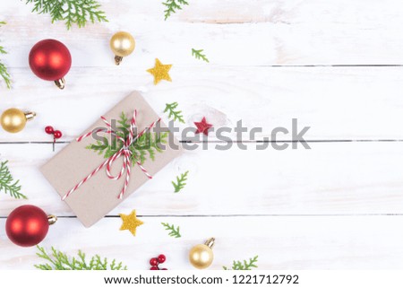 Christmas background concept. Top view of Christmas gift box with spruce branches, pine cones, red berries and bell on white wooden table background.