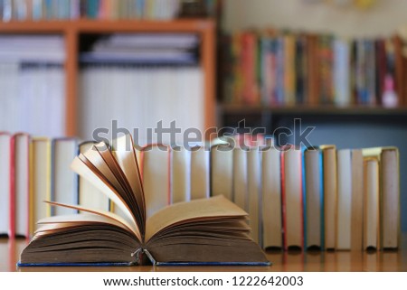 Close-up of old books opened on the library table many books are arranged in the background selective focus and shallow depth of field