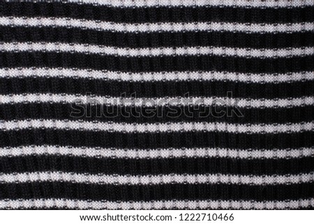 Black and white striped knitted fabric. Close up. Fashionable concept