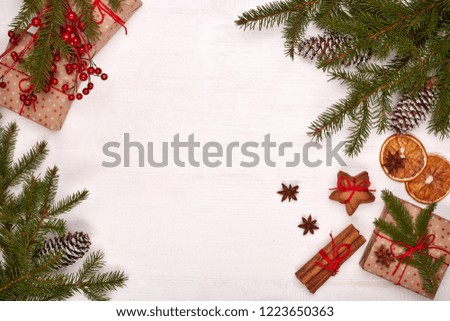 Fir branches, cones and gift boxes on a white wooden background. Top view with copy space. New Year and Christmas