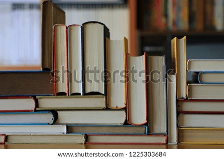 Close-up of multi-colored books stacked on a table in a library selective focus and shallow depth of field