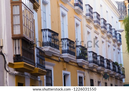 Building and street in Seville, Spain, details of old facade, wall with wooden frame windows.