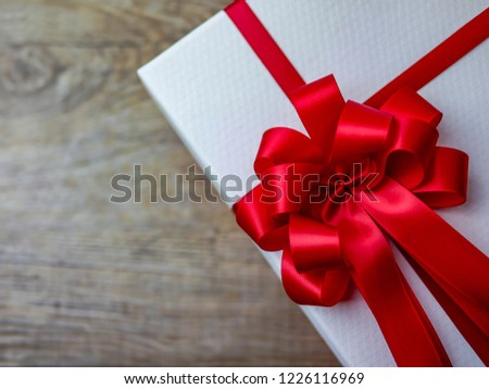 Luxury red satin ribbon bow gift box on composition space / top view