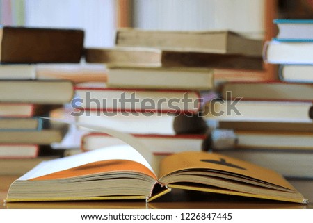 Close-up of books opened on library table many books stacked as backgrounds selective focus and shallow depth of field
