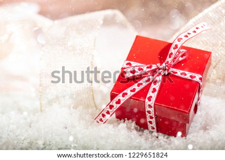 Christmas red gift box on abstract bokeh lights and glitter background, copy space
