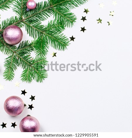 Christmas background with fir tree branches, pink and beige decorations, silver ornaments. Copy space, top view