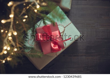 Holiday gift boxes with red decor under Cristmas tree in holiday eve. Boxing day. Xmas night. Copy space.