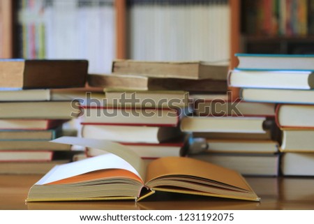 Close-up of books opened on library table many books stacked as backgrounds selective focus and shallow depth of field