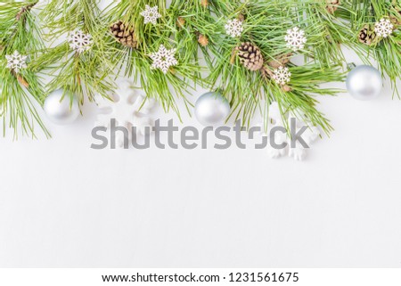 Holiday background with christmas branches and  balls on a light background