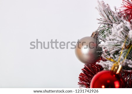 Christmas decoration red and silver balls in a tree with tinsel and pinecone in snow