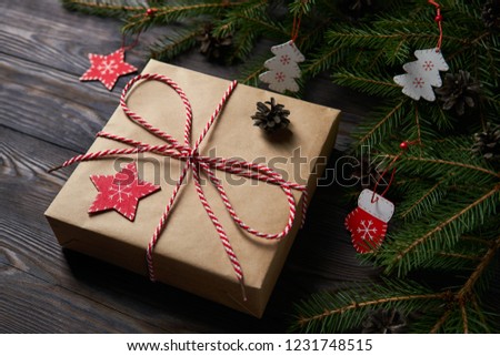 Top view of arranged wrapped present with green fir tree branches on wooden table