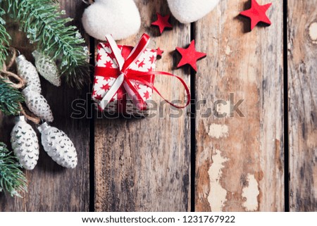 Christmas background with copy space, red gift box with stars and heart on dark wooden background in vintage style