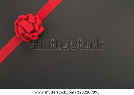 Decorative red ribbon and bow on a dark background 