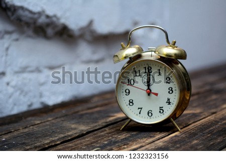 old alarm clock on white brick wall background