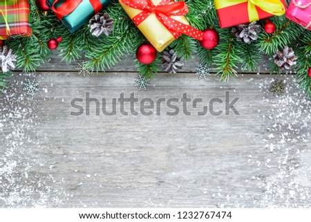 happy new year or christmas decoration background made of fir tree, decorations, gift boxes and pine cones on rustic wooden table covered with snow. Flat lay. top view with copy space