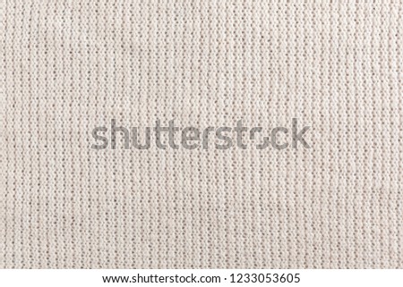 Knitted white sweater pattern background. Natural woolen fabric, sweater fragment. Copy space.
