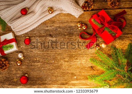 Christmas gift giving concept - christmas presents in red and white boxes on wooden table, flat lay scene with copy space on aged wood background, retro toned