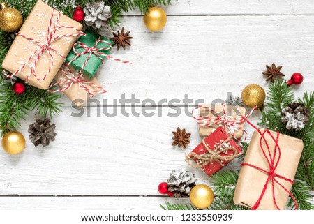 christmas composition made of fir branches, gift boxes, decorations and pine cones on white wooden table covered with snow. Christmas background. Flat lay. top view with copy space