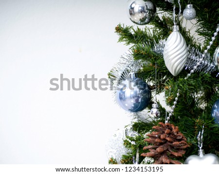 Christmas tree adorned with balls and stars, silver and blue, white background