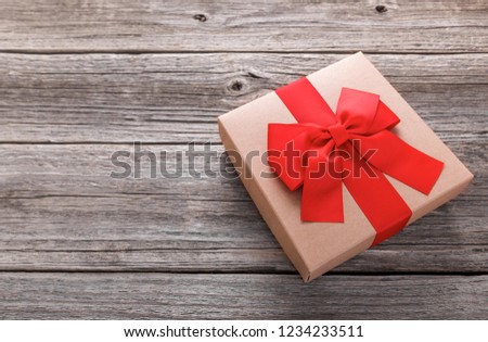 Stylish gift box on the background of wooden boards. There is free space.