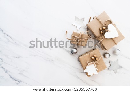 Christmas handmade gift boxes on white marble background top view. Merry Christmas greeting card, frame. Winter xmas holiday theme. Noel. Happy New Year. Flat lay