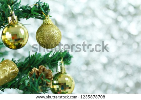 golden Christmas ball adorned on a tree on blurred background.