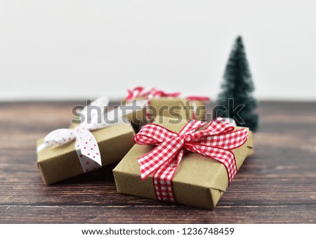 Brown Christmas and New Year gift boxes with red and white ribbon and Christmas ornaments on dark wooden table and white background with copy space for text, festive and celebration concept
