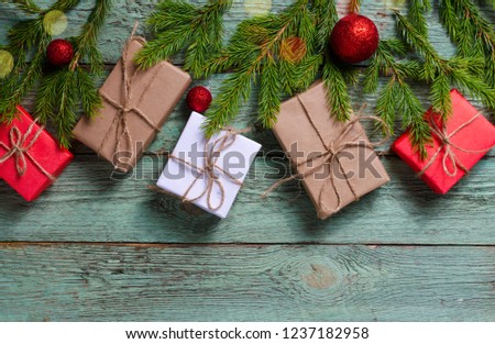 Christmas composition with presents and fir branches on rustic turquoise wooden board.