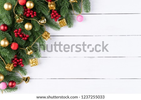Christmas background concept. Top view of Christmas gift box red balls with spruce branches, pine cones, red berries and bell on old wooden background.