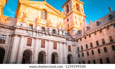 Basilica at the monastery and royal residence of Spanish kings, San Lorenzo de El Escorial near the Spanish capital city of Madrid at sunset, golden hour with blue sky and sunlight reflecting at tower