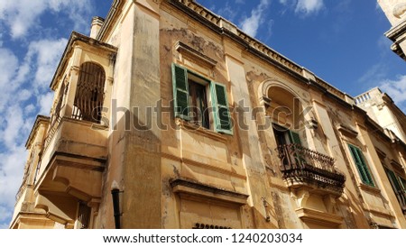 An old building with windows and a balcony in Mdina.