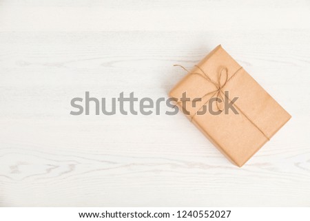 Parcel decorated with twine and space for text on wooden background, top view