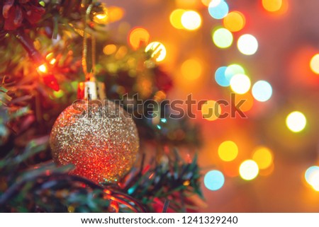 Christmas decoration. Hanging gold balls on pine branches christmas tree garland and ornaments over abstract bokeh background with copy space