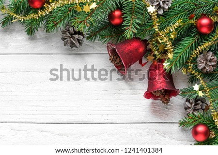 Christmas background with fir tree, christmas bells, berries, decorations and pine cones on white wooden table with copy space for your text. top view. flat lay