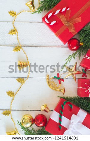 Christmas red gift boxes with green pine and decorating ornaments on white wood panel background, border design with copy space,or new year frame composition,top view