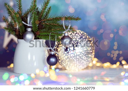 winter holiday decorations with green fir tree branches, christmas balls and glowing christmas lights