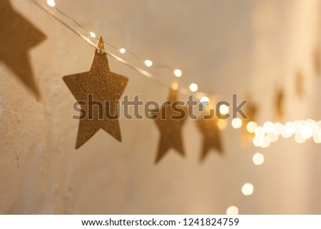 Merry Christmas and happy New year. Stylish holiday decor. Background for new year cards. Warm star-shaped light garlands, festive decorations with copy space. Christmas concept