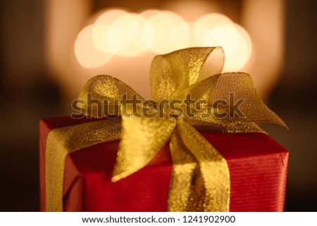 red present with golden bow on blurred background