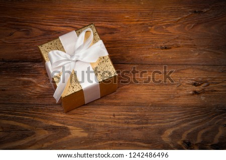 one decoratively wrapped gift on a wooden table