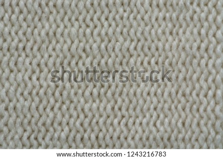 Knitted texture. Pattern fabric made of wool. Background, copy space. Handmade sweater texture, knitted wool pattern, ivory background